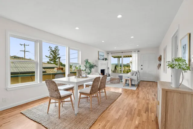 a kitchen with a stove a refrigerator and white cabinets with wooden floor