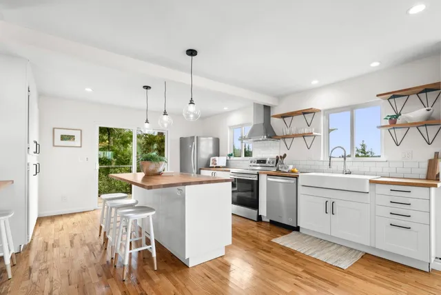 a dining hall with stainless steel appliances granite countertop furniture and wooden floor