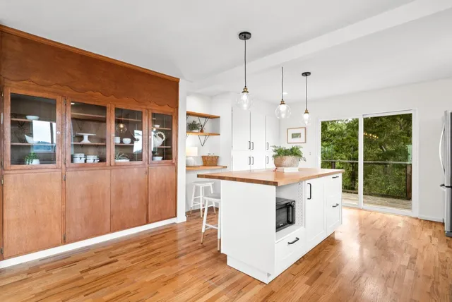 a kitchen with stainless steel appliances granite countertop a sink a stove and a wooden floors