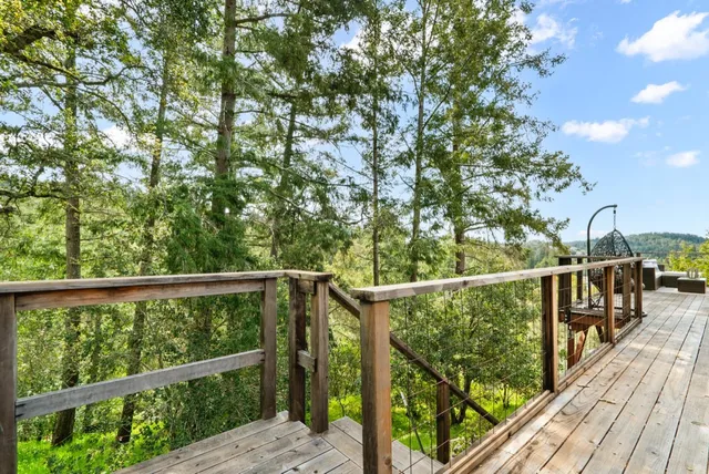a view of a roof deck with couches and wooden floor