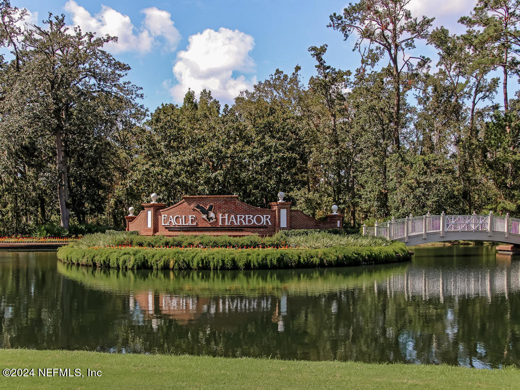 2771 Shade Tree Drive Fleming Island, FL 32003 - Photo 23 of 40 a view of a lake with a building in the background