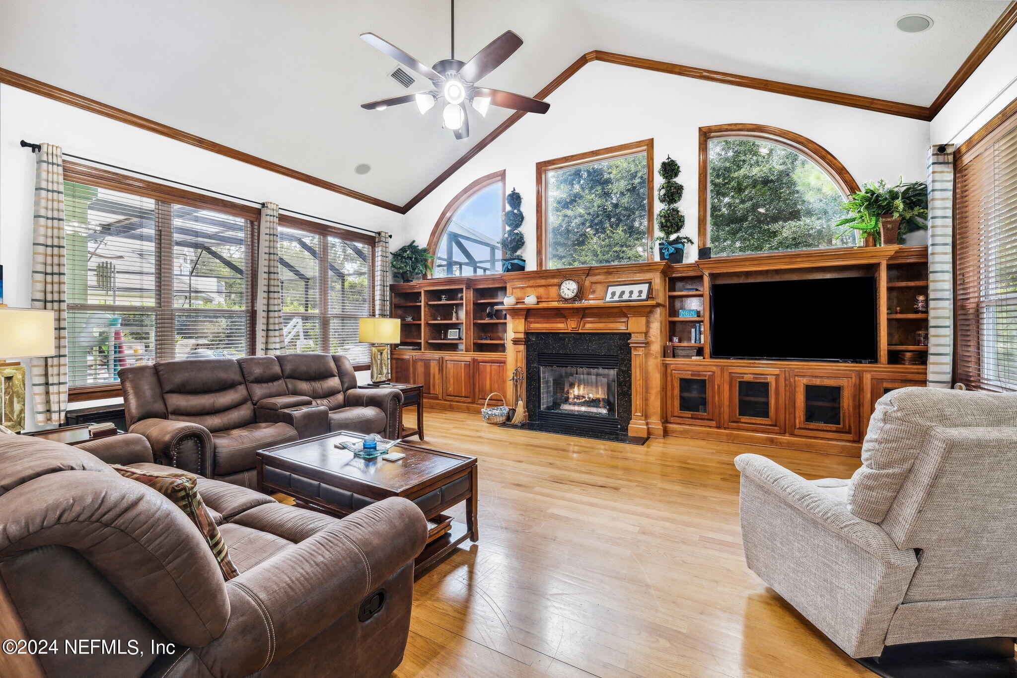 2771 Shade Tree Drive Fleming Island, FL 32003 - Photo 5 of 40 a living room with furniture a fireplace and a floor to ceiling window