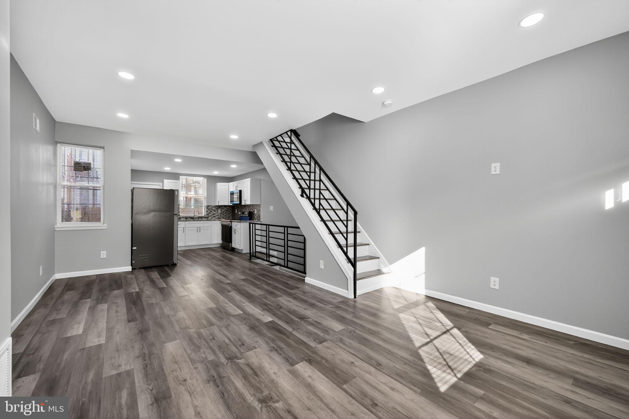 4516 North Mole Street Philadelphia, PA 19140 - Photo 7 of 30 a view of a livingroom with wooden floor stairs and a kitchen