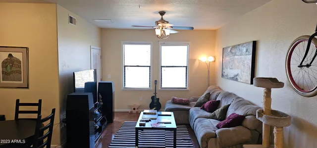 a living room with furniture a chandelier and a window