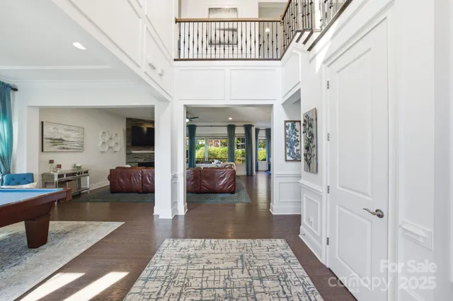 a living room with a table a clock and a large window