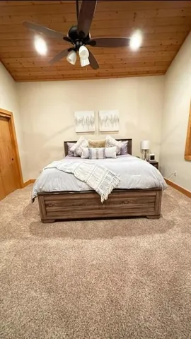 a spacious bedroom with a bed and a ceiling fan