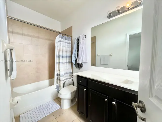 a bathroom with a sink a toilet a mirror and shower