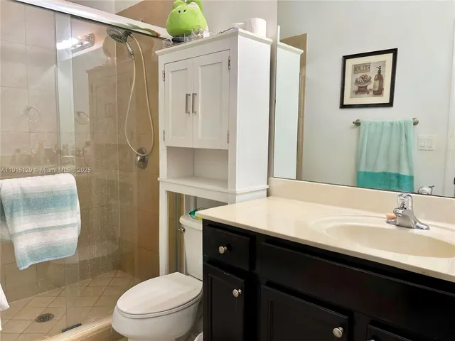 a bathroom with a sink a toilet a shower and a mirror