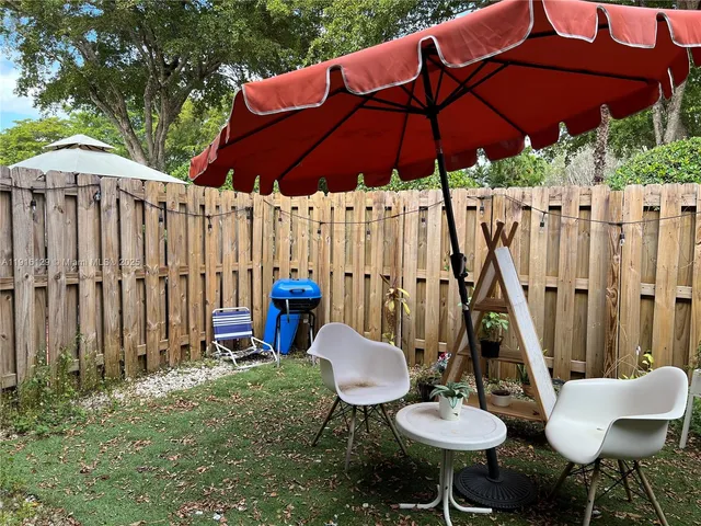 a backyard of a house with table and chairs