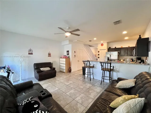 a living room with furniture and kitchen view