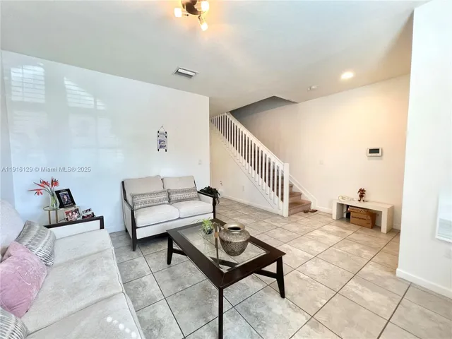 a living room with furniture and a potted plant
