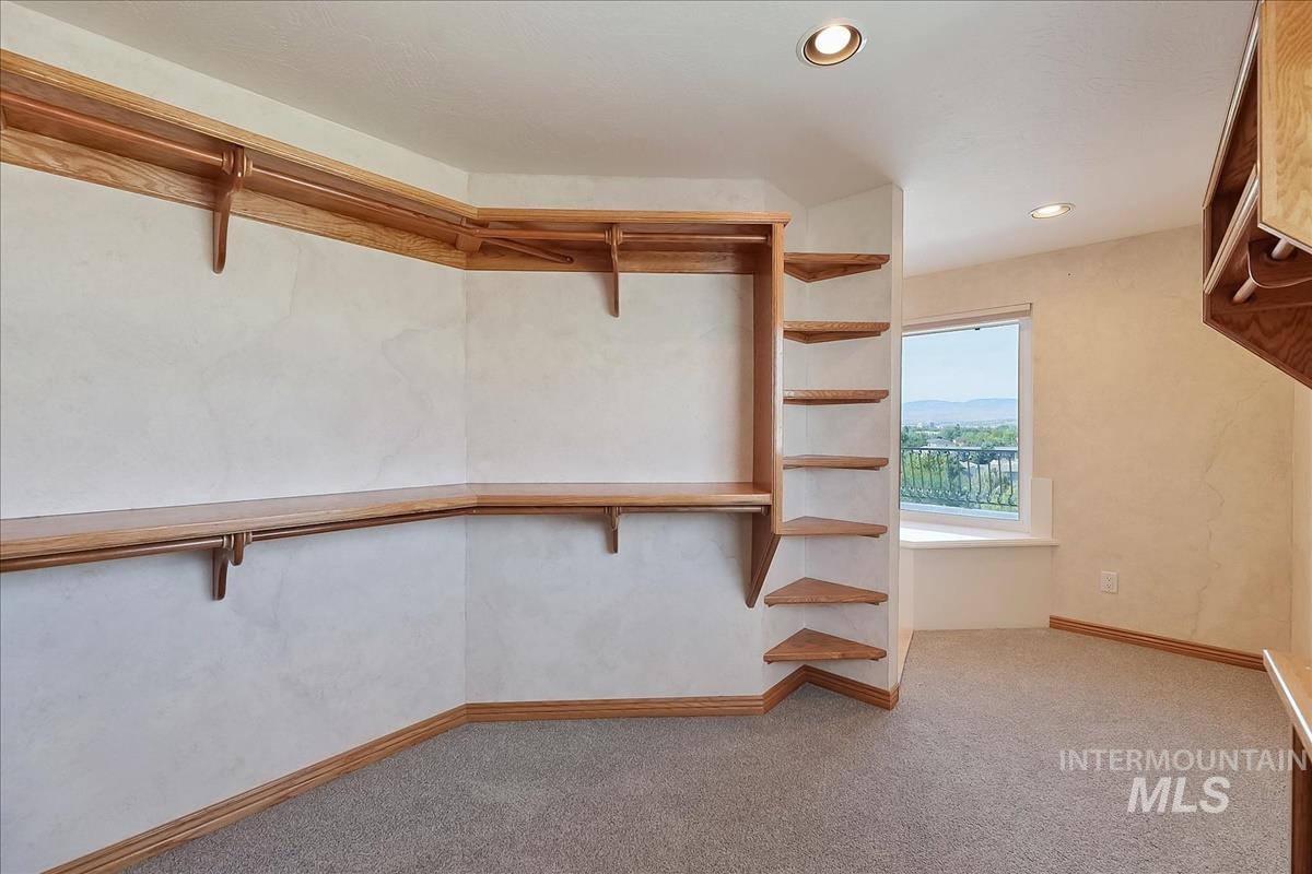 2804 West Sunrise Rim Road Boise, ID 83705 - Photo 41 of 50 Walk-in closet featuring extensive wood shelving, integrated hanging rods, recessed lighting, and a window with a built-in window seat