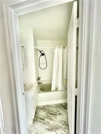 a view of a bathroom with bathtub and shower