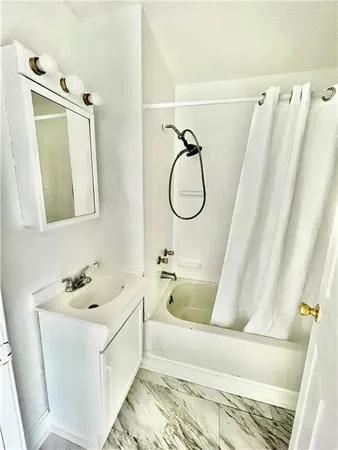 a bathroom with a sink a window and tub