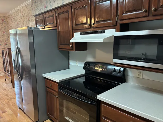 a close view of a stove top oven and refrigerator