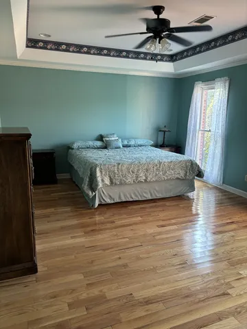 a bedroom with a bed and wooden floor