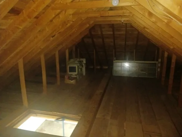 a view of an empty room with wooden floor a fireplace and a window