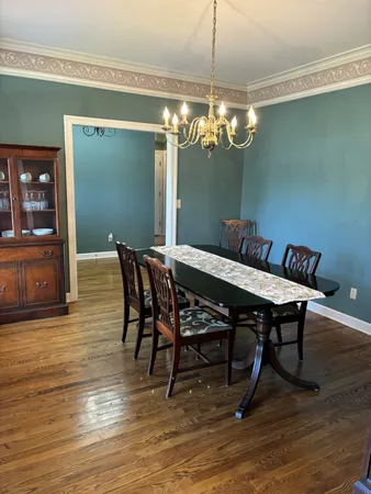 a view of a dining room with furniture wooden floor and chandelier