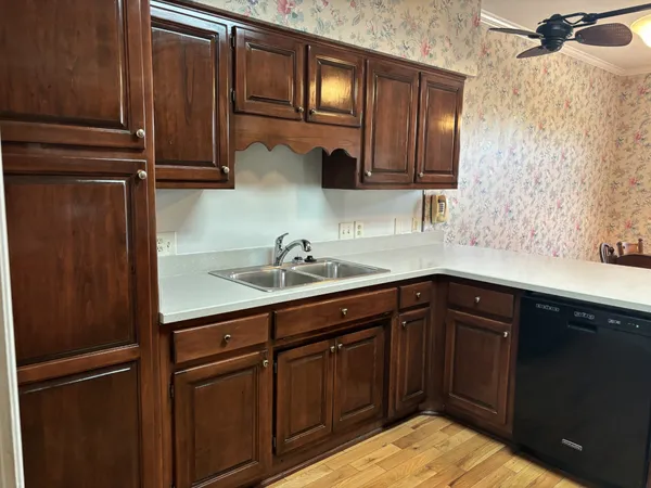 a kitchen with stainless steel appliances granite countertop wooden cabinets and a sink