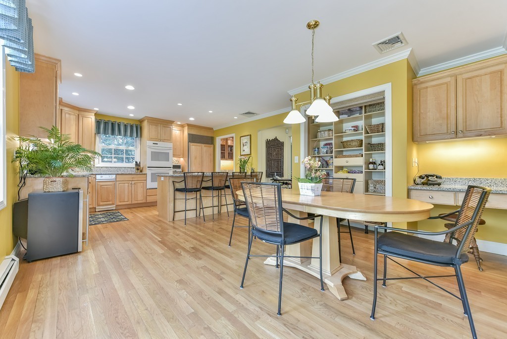 15 Whitney Road Newton, MA 02460 - Photo 9 of 23 a kitchen with stainless steel appliances granite countertop a stove top oven a dining table and chairs with wooden floor