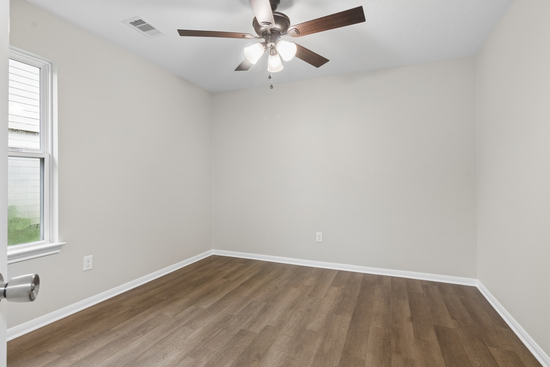 7811 Adonis Avenue Baytown, TX 77521 - Photo 31 of 36 an empty room with a window and a fan