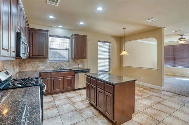 a kitchen with stainless steel appliances granite countertop a sink counter space cabinets and a large window