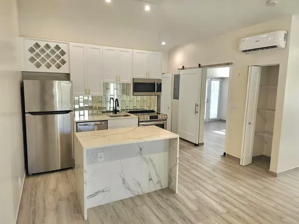 a kitchen with stainless steel appliances a refrigerator and a stove top oven