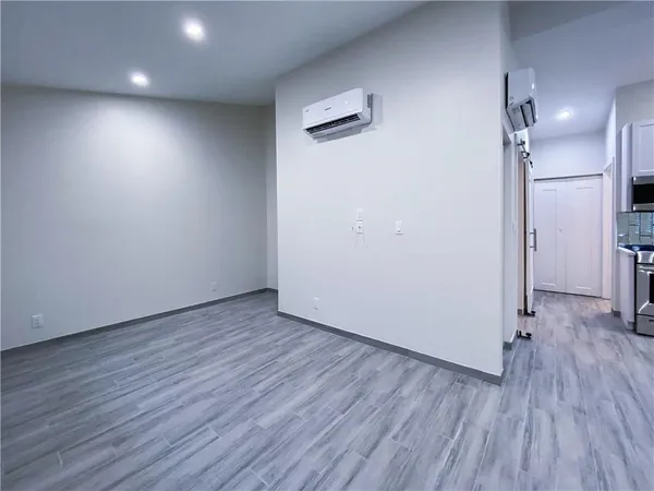 an empty room with wooden floor and a ceiling fan