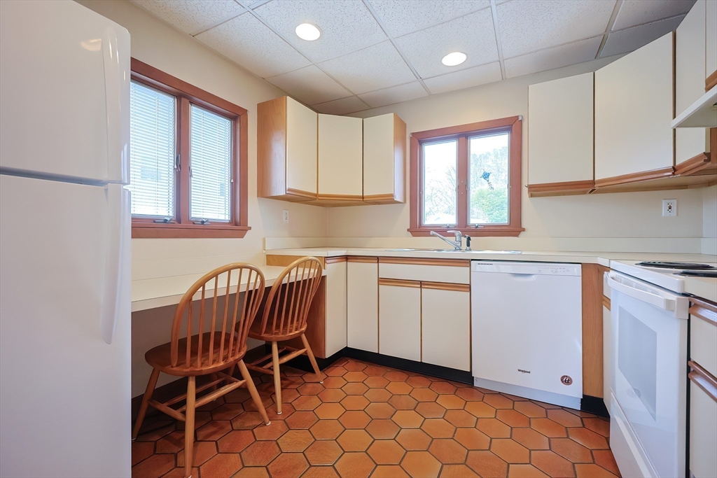 32 Sexton Avenue Westwood, MA 02090 - Photo 9 of 33 a kitchen with a chair and white cabinets