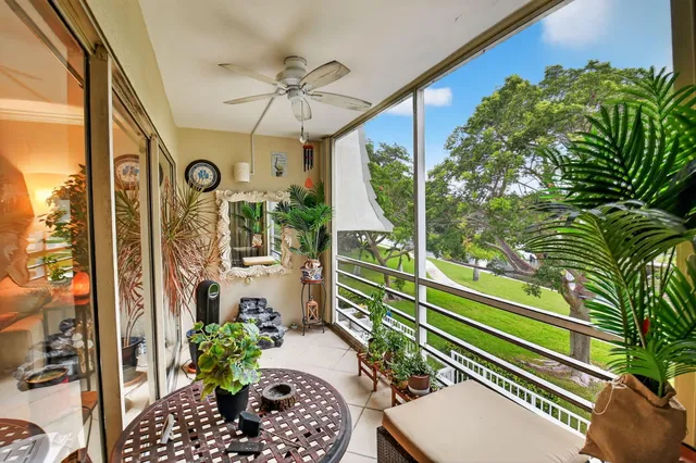 a view of a balcony with chairs and a potted plant