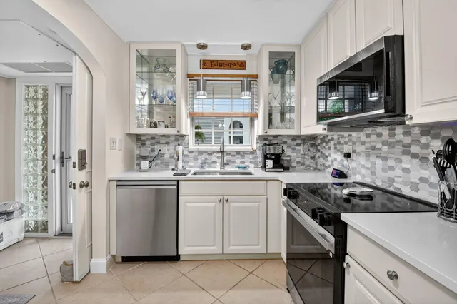 a kitchen with cabinets appliances a sink and a window