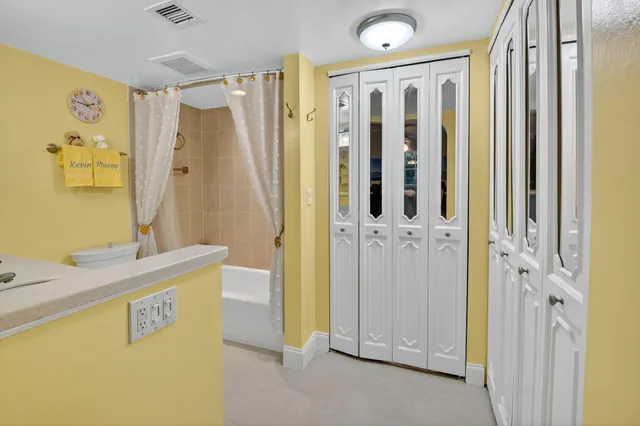 a bathroom with a granite countertop shower a sink and a mirror