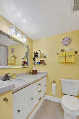 a spacious bathroom with a granite countertop toilet sink and mirror