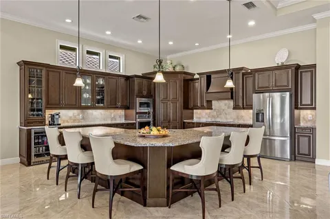 a kitchen with stainless steel appliances kitchen island granite countertop a dining table and chairs