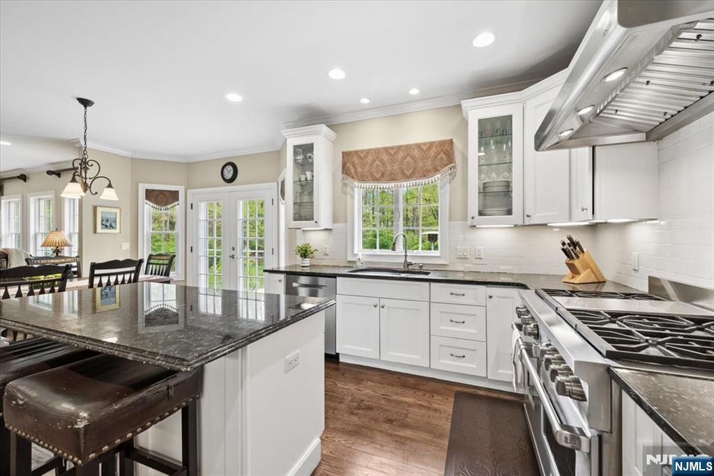 8 Forest Drive Mendham, NJ 07945 - Photo 16 of 43 a kitchen with granite countertop a stove a sink dishwasher and cabinets with wooden floor