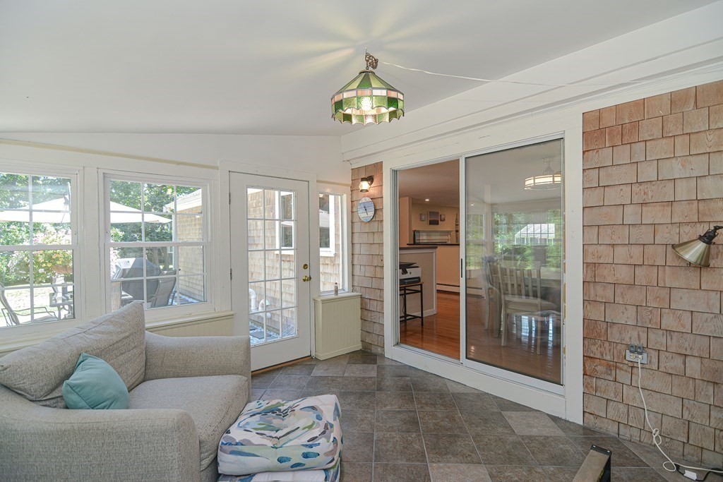 61 Tarpon Road Falmouth, MA 02536 - Photo 17 of 42 a living room with furniture a chandelier and a glass door