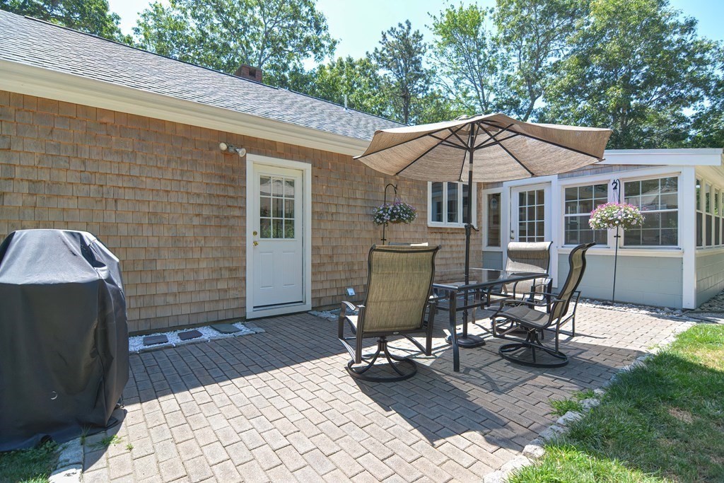 61 Tarpon Road Falmouth, MA 02536 - Photo 19 of 42 a view of a patio with table and chairs near a barbeque