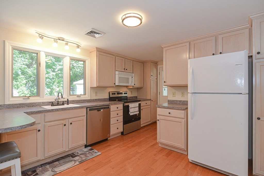 61 Tarpon Road Falmouth, MA 02536 - Photo 22 of 42 a kitchen with white cabinets and white appliances