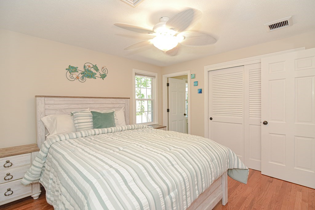 61 Tarpon Road Falmouth, MA 02536 - Photo 32 of 42 a bedroom with a large bed and a chandelier