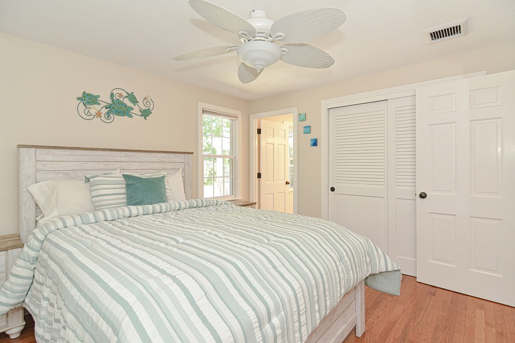 61 Tarpon Road Falmouth, MA 02536 - Photo 35 of 42 a bedroom with a large bed and a chandelier