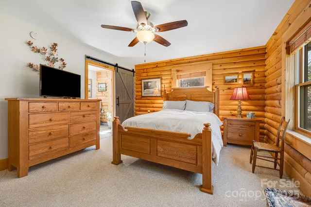 a bedroom with a bed and a flat tv screen on dresser