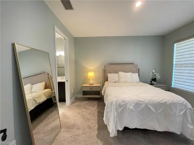 a bedroom with a bed and a large mirror