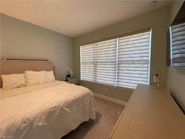a large bed sitting in a bedroom next to a window