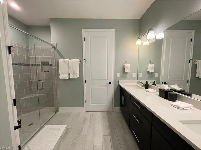a spacious bathroom with a double vanity sink a toilet and shower