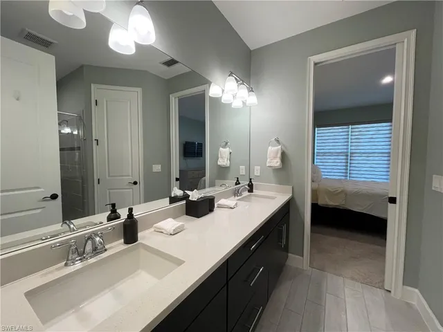 a en suite bathroom with double vanity and a mirror