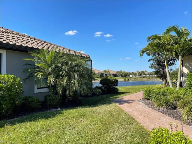 a backyard of a house with lots of green space and lake view