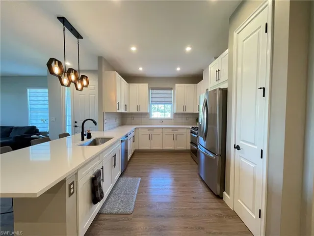 a kitchen with stainless steel appliances a stove a sink a refrigerator and a center island