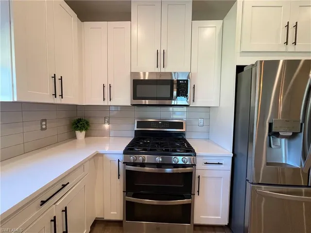 a kitchen with stainless steel appliances a stove a refrigerator and a sink