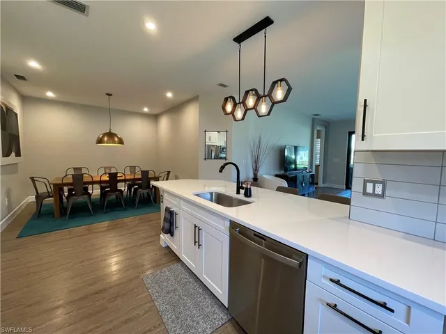 a kitchen with a sink a stove and chairs