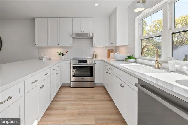 a kitchen with granite countertop a table chairs stove and cabinets
